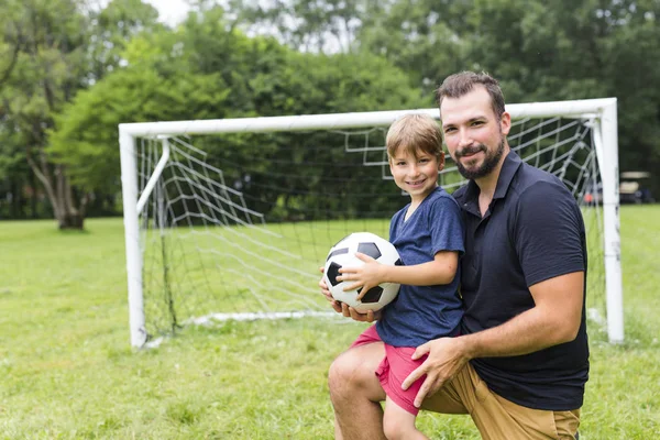 Far med son spela fotboll på fotbollsplan — Stockfoto