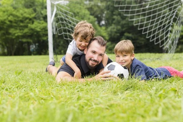 Far med son spela fotboll på fotbollsplan — Stockfoto