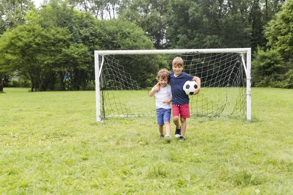 Dos hermanos divirtiéndose jugando con pelota — Foto de Stock