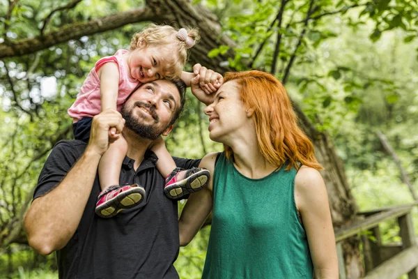 Young father and mother with their cute little daughter — Stock Photo, Image