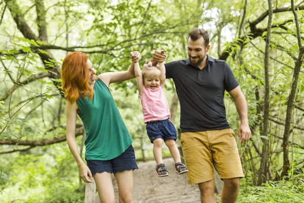 Mor, far och dotter på strandpromenaden. Första stegen — Stockfoto