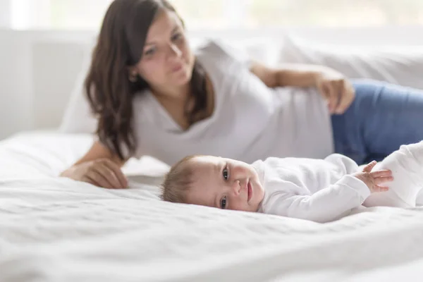 Feliz familia amorosa. Madre jugando con su bebé en el dormitorio. — Foto de Stock