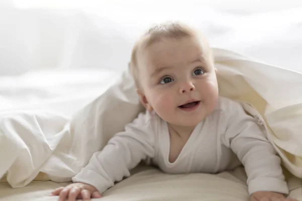 Schattig gelukkig 7 maanden baby meisje in luier liegen en spelen — Stockfoto