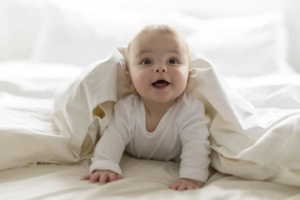 Schattig gelukkig 7 maanden baby meisje in luier liegen en spelen — Stockfoto