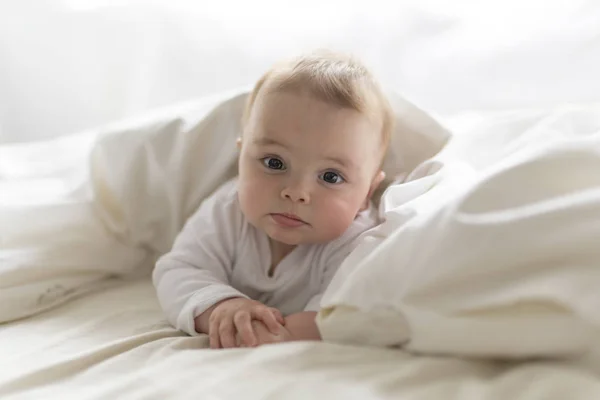 Bonito feliz 7 meses bebê menina na fralda mentindo e jogando — Fotografia de Stock