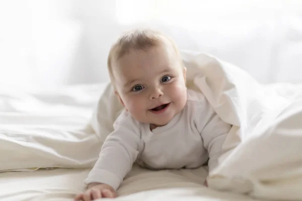 Schattig gelukkig 7 maanden baby meisje in luier liegen en spelen — Stockfoto