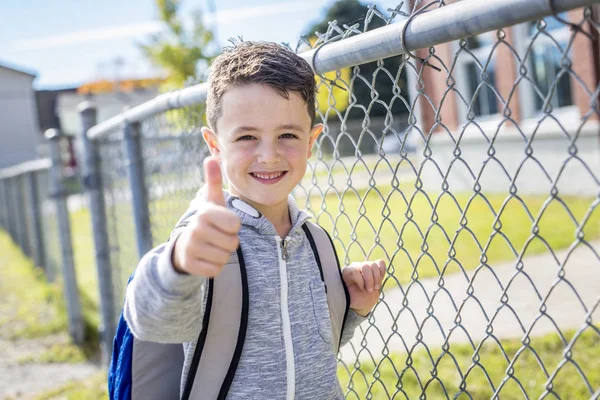 Estudiante fuera de la escuela de pie sonriendo — Foto de Stock