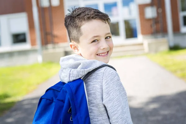 Студент перед школой улыбается — стоковое фото