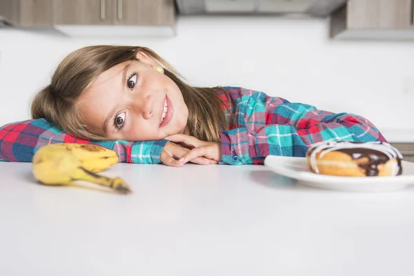 Kind kiezen tussen gezonde groenten en lekkere snoepjes — Stockfoto
