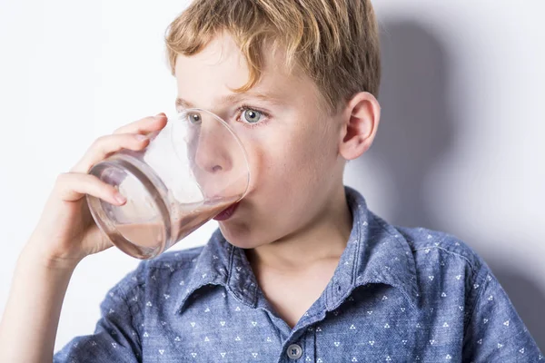 Gelukkig lachend kind chocolade consumptiemelk geïsoleerd op wit — Stockfoto