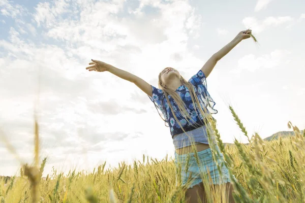 Rozkošná holčička hraje v pšeničném poli v teplý letní den — Stock fotografie