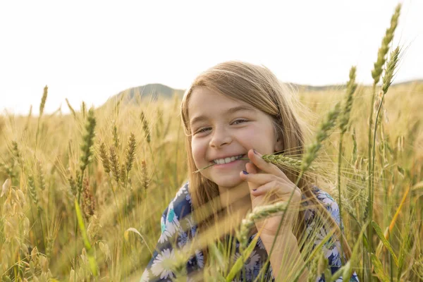 Rozkošná holčička hraje v pšeničném poli v teplý letní den — Stock fotografie
