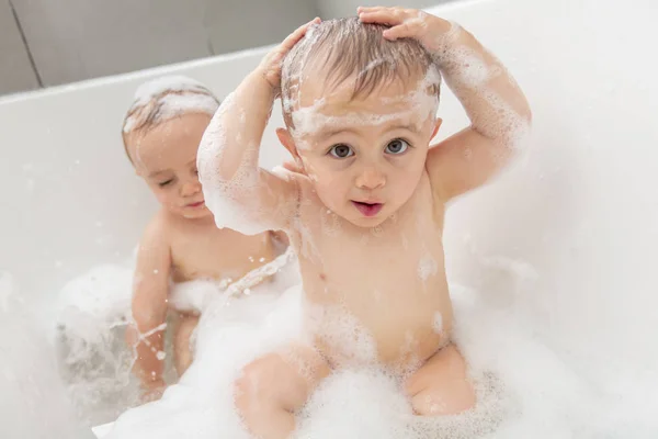 Dois meninos se divertindo com água tomando banho na banheira — Fotografia de Stock