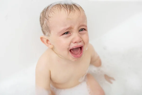 Bebé llorando en una bañera. Niño lactante gritando mientras toma un baño . — Foto de Stock