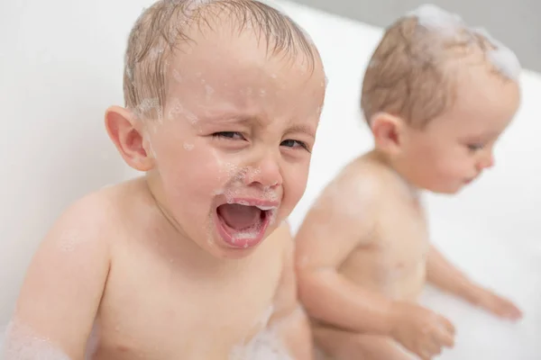 Bebé llorando en una bañera. Niño lactante gritando mientras toma un baño . — Foto de Stock