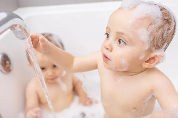 Zwei kleine Jungen haben Spaß mit Wasser, indem sie in der Badewanne baden — Stockfoto