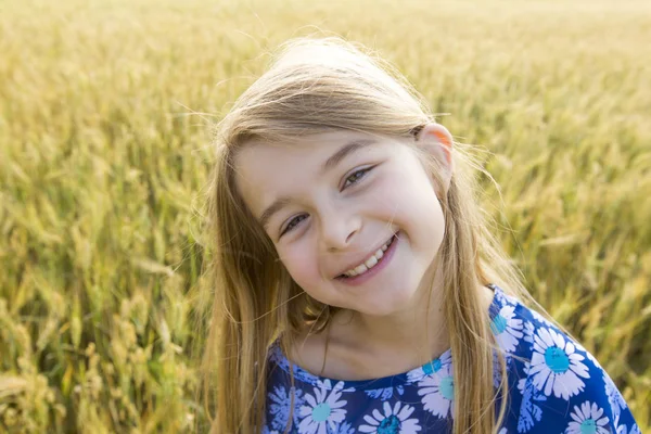 Adorable petite fille jouant dans le champ de blé par une chaude journée d'été — Photo