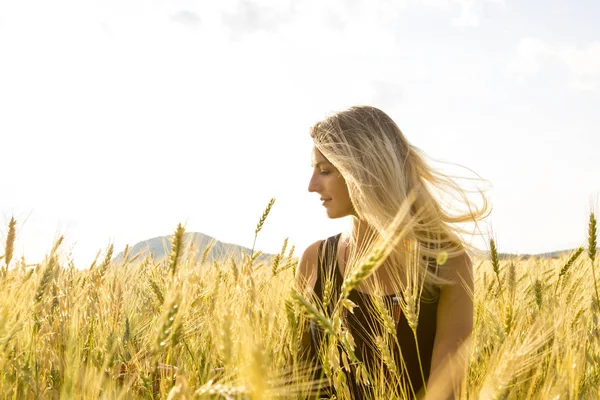 Felice, soddisfatta giovane donna in piedi nel campo di grano . — Foto Stock