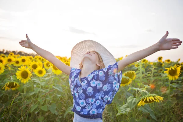 幸せな女の子の夏夕日にひまわり畑に — ストック写真