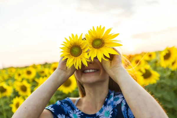 Happy girl on a field of sunflowers on summer sunset — Stock Photo, Image