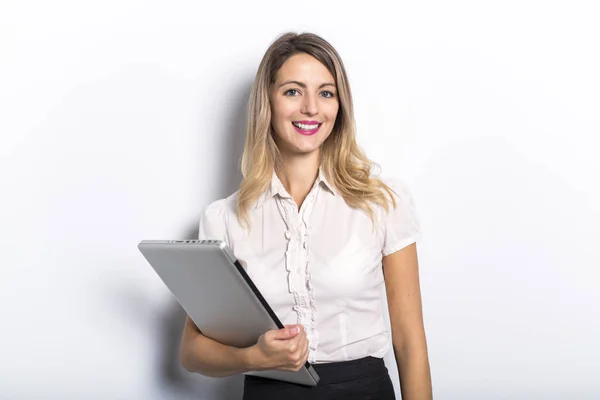 Young business woman offers computer product, on grey background — Stock Photo, Image