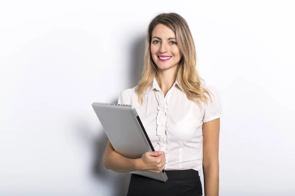 Junge Geschäftsfrau bietet Computerprodukt auf grauem Hintergrund an — Stockfoto