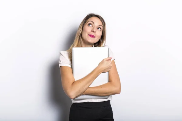 Young business woman offers computer product, on grey background — Stock Photo, Image