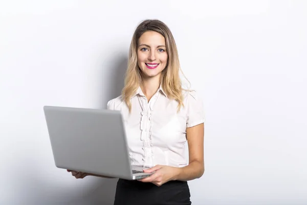 Young business woman offers computer product, on grey background — Stock Photo, Image