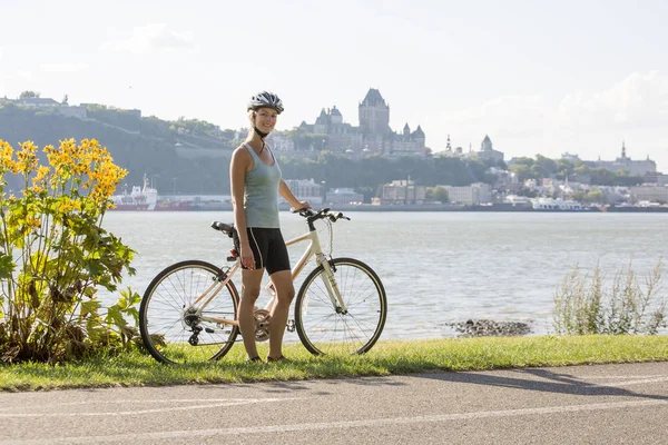 Jovem mulher andar de bicicleta fora com vista quebec — Fotografia de Stock