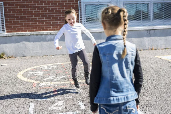 Hopscotch op het schoolplein met vrienden spelen samen — Stockfoto