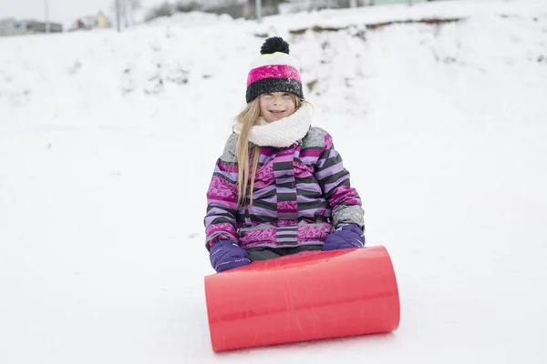 Niña montando en toboganes de nieve en invierno — Foto de Stock