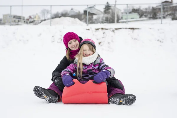 Niña montando en toboganes de nieve en invierno — Foto de Stock