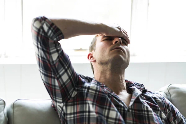 Young man suffering from headache at home — Stock Photo, Image