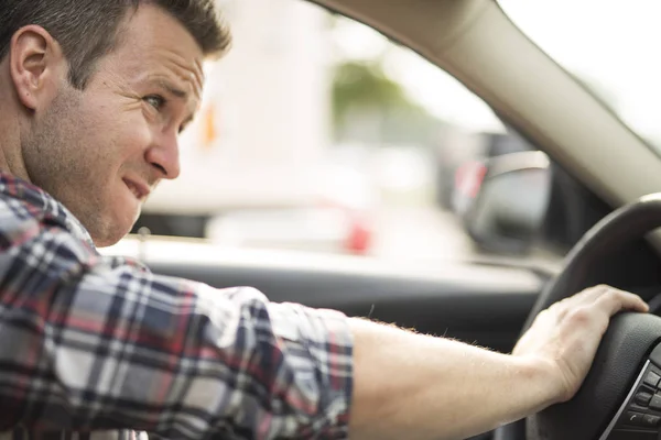 Irritierter junger Mann am Steuer eines Autos. Irritierter Fahrer — Stockfoto