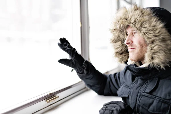Homme avec des vêtements chauds sentant le froid à l'intérieur de la maison près d'une fenêtre — Photo