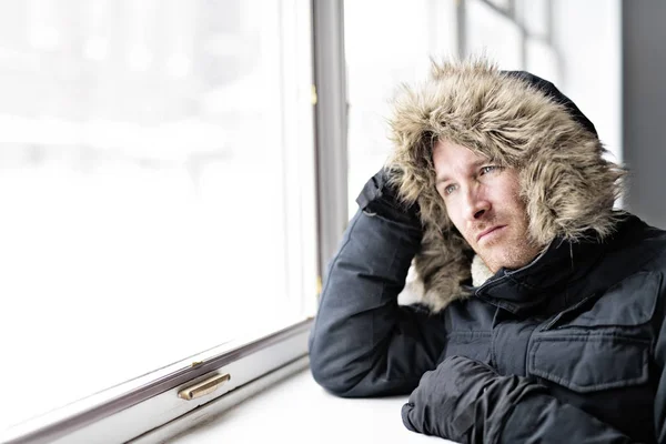 Homme avec des vêtements chauds sentant le froid à l'intérieur de la maison près d'une fenêtre — Photo