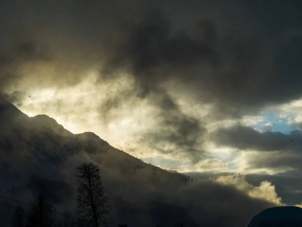 Sis ve bulutlarla kaplı dağ manzarası 