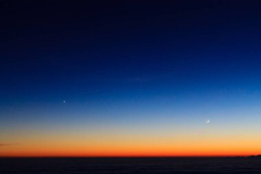 Dağ siluet moon ile alacakaranlıkta gökyüzü bulutlar üzerinde