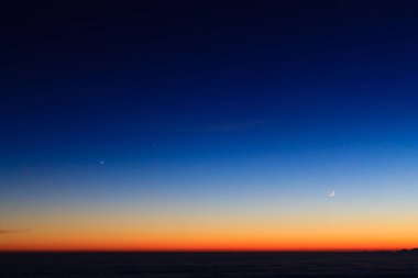Dağ siluet moon ile alacakaranlıkta gökyüzü bulutlar üzerinde