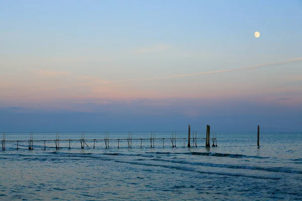 Пляжный пейзаж на рассвете с луной — стоковое фото