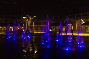 MILAN, ITALY-ECTOBER 30, 2016: Finans bölgesi gece görüşü. Aydınlatılmış su çeşmeleri. Gae Aulenti meydanındaki modern gökdelenler. Unicredit banka kulesi