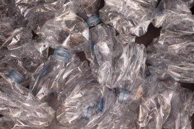 Plastik şişelerin arka planı. Siyah yüzeyde boş şişeler
