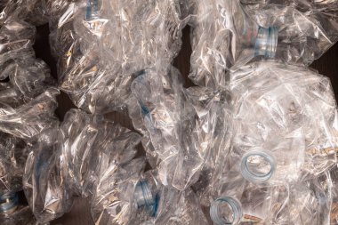Plastik şişelerin arka planı. Siyah yüzeyde boş şişeler