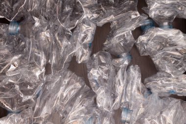 Plastik şişelerin arka planı. Siyah yüzeyde boş şişeler