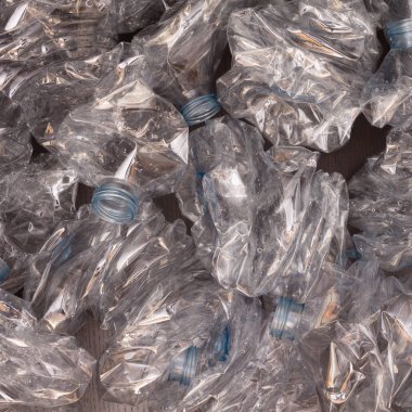 Plastik şişelerin arka planı. Siyah yüzeyde boş şişeler