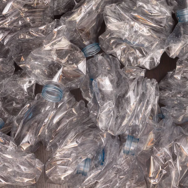 Plastik şişelerin arka planı. Siyah yüzeyde boş şişeler