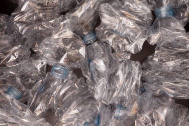 Plastik şişelerin arka planı. Siyah yüzeyde boş şişeler