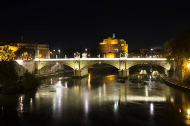Roma, Tevere nehri ve Hadrian Mozolesi gece sahnesi. İtalyan simgesel yapı