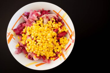 Siyah masada mısırlı salata, üst manzara. Gıda arkaplanı