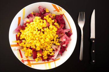 Siyah masada mısırlı salata, üst manzara. Gıda arkaplanı
